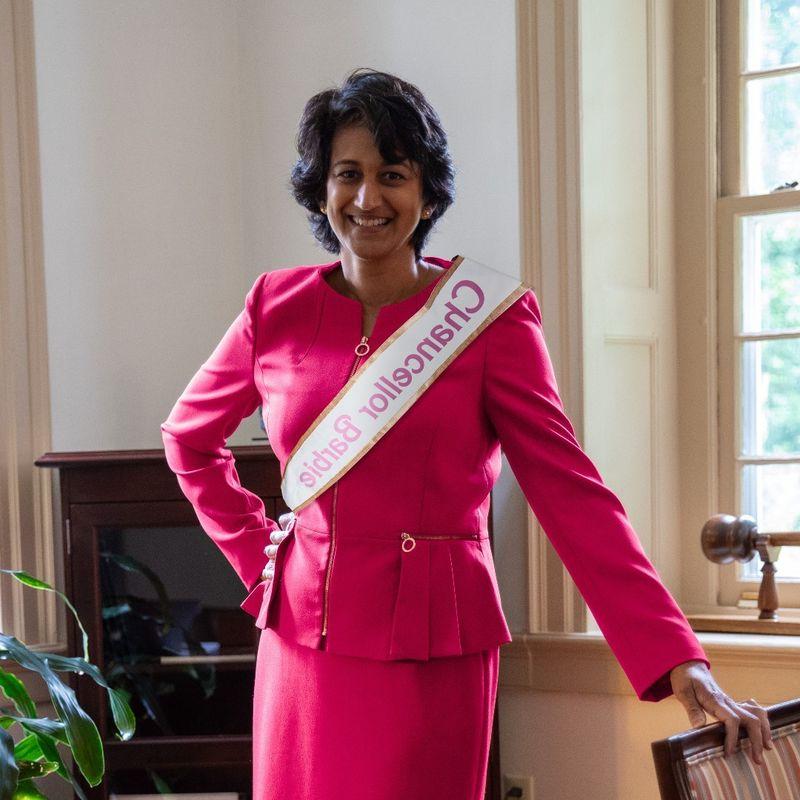 Radha Pyati wears a pink power suit with a ribbon reading "Chancellor Barbie"